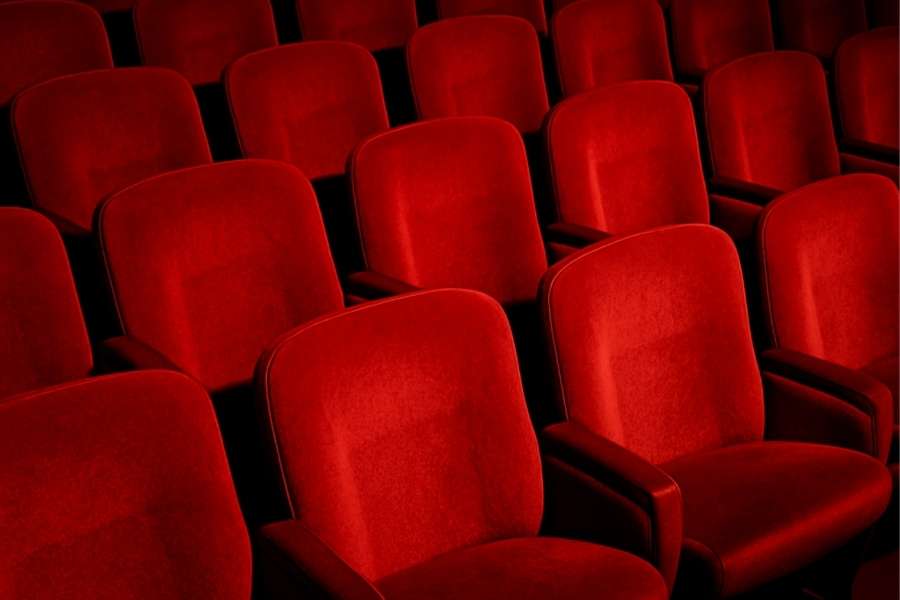 Rangées de fauteuils rouges en velours dans une salle de théâtre immersif
