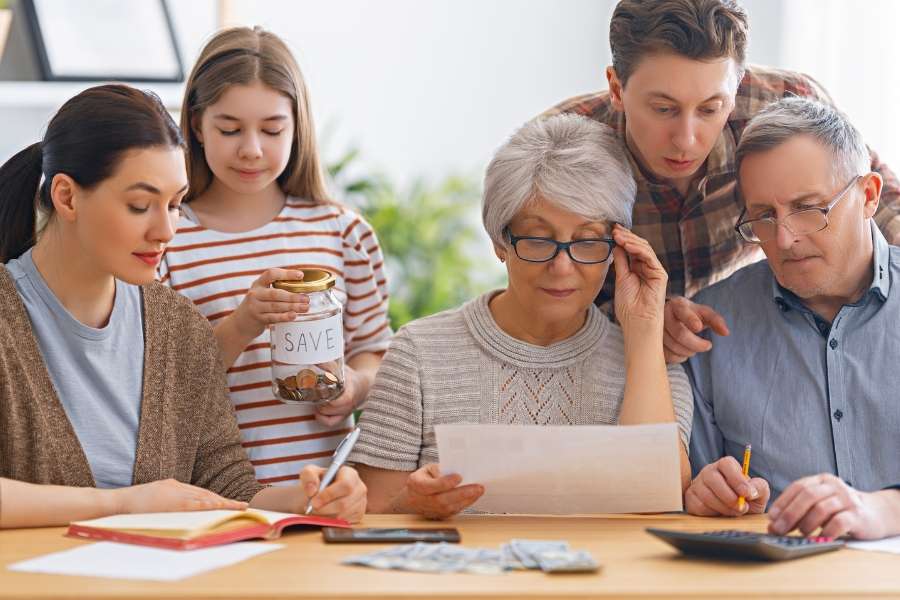 Une famille intergénérationnelle travaillant ensemble pour planifier et optimiser son budget familial.